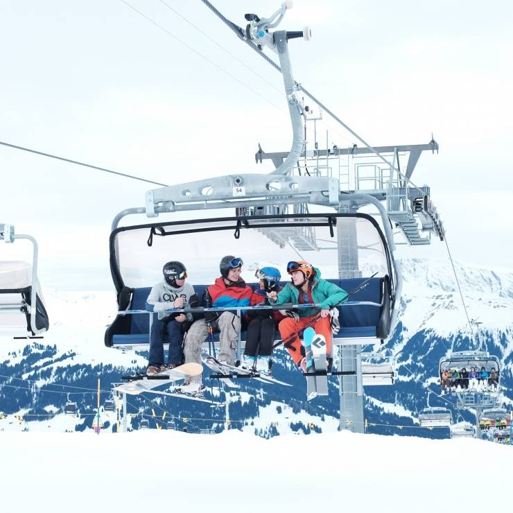 Freunde auf Sessellift im Winter